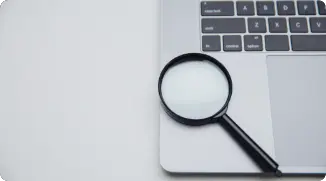 Notebook com uma lupa embaixo do teclado